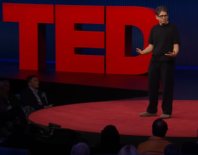 A person on the TED stage giving a TED Talk.